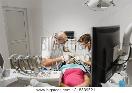 Close Up Process Of Preparing And Installing Dental Ceramic Crown. Male Professional Dentist Helps T