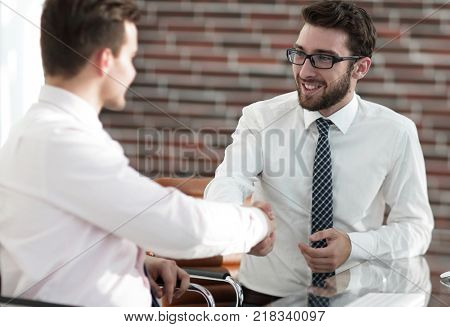 handshake colleagues sitting at your Desk