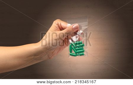Naked, female hand giving drugs in plastic bag