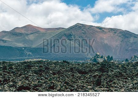 Landscape of Timanfaya National Park in Lanzarote, Canary Islands, Spain. Red and black volcanic mountains.