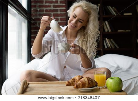 Young Happy Woman having Breakfast in Bed