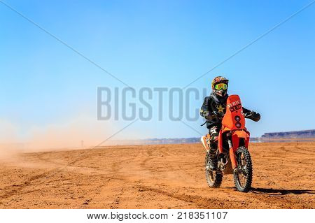 Ait Saoun Morocco - February 22 2016: Unidentified man in helmet riding bike in Ait Saoun desert of Morocco.