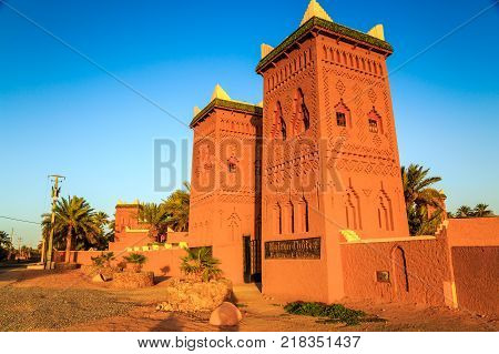 M'hamid Morocco - February 22 2016: typical arabic style front view of Chez le Pacha hotel outside view with blue sky