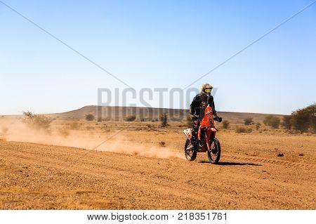 Ait Saoun Morocco - February 23 2016: Man riding quad bike in Ait Saoun desert in Morocco against the blue sky.