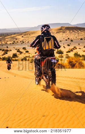 Ait Saoun Morocco - February 25 2016: back vue of man in helmet riding bike in Ait Saoun desert of Morocco