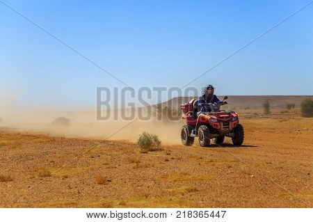 Man enjoying atv quad ride bike in desert on a bright sunny day