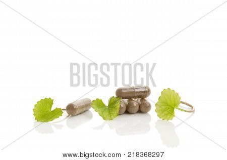 Gotu kola gel-capsules with leaves isolated on white background. Asiatic pennywort.