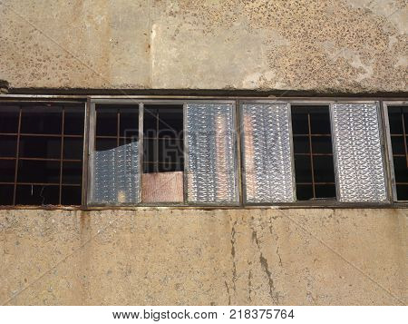 Abandoned building with concrete walls and smashed windows