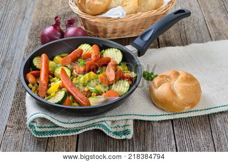 Short fried Vegetables with spicy Debreziner sausages served in a frying pan
