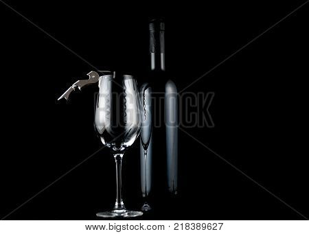 Empty wine glass with corkscrew vine bottle in background