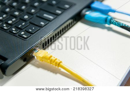 Various cables connected to the laptop in white background