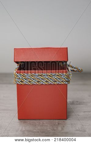 Red gift box on a white and wooden background. Loot box for game.
