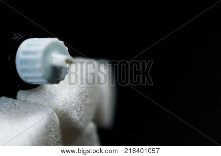 Sugar cubes on focus, insulin pen on the top, diabetes prevention conceptual image.