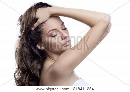 Beautiful girl with healthy brown hair. Beautiful brunette woman touching her long hair. Hair cosmetics, haircare. SPA concept. Isolated on white background.