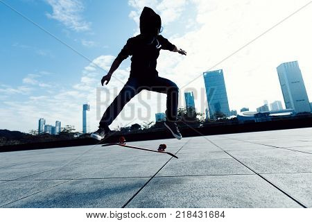 female skateboarder doing a hand on skateboard in city