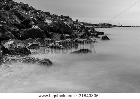 Waves crash over rocks on beach in Essex
