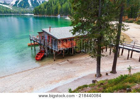 Old wooden house on the Braies lake in the background of Seekofel mountain in DolomitesItaly ( Pragser Wildsee )