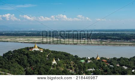 High angle view of multiple temples and pagodas on the mountains with Irrawaddy river in the background from sagaing hill, Sagaing region of Myanmar.