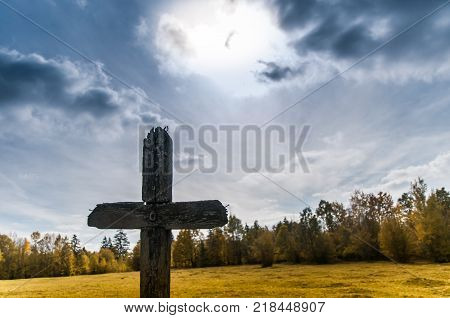 Old wood cross, in the woods ,autumn landscape.