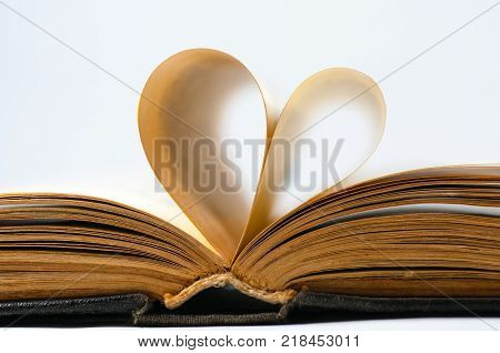 Heart shaped old book pages isolated on white.