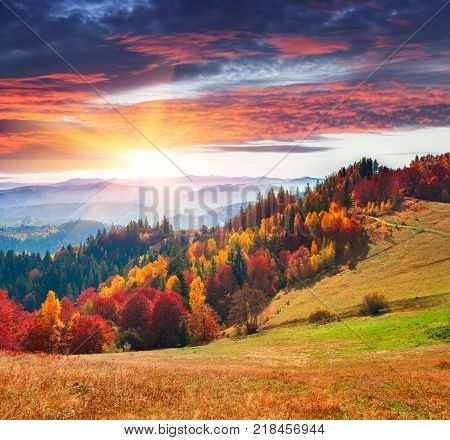 Colorful autumn morning in the Carpathians. Dramatic sunrise in the mountain village. Artistic style post processed photo.