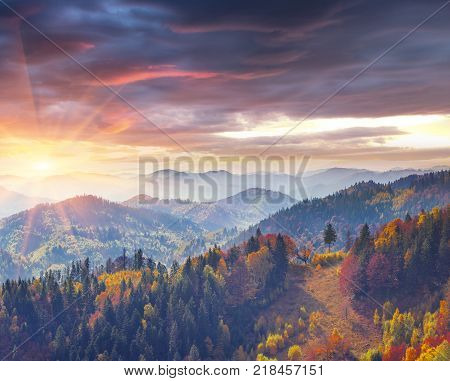 Colorful autumn morning in the Carpathians. Dramatic sunrise in the mountain village. Artistic style post processed photo.