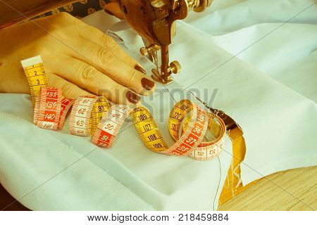 closeup of woman hands sewing yellow cloth outdoors. Woman's Hand Sewing Quilt