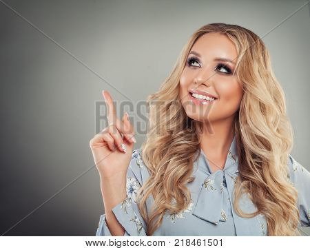 Perfect Young Woman Pointing her Finger Up on Gray Background