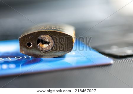 Padlock on credit card, laptop, credit card security conceptual image.