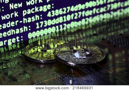 The digital process of cryptocurrency mining by using the GPUs. Bitcoins and video card on a working display and mining screen