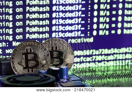 The digital process of cryptocurrency mining by using the GPUs. Bitcoins and video card on a working display and mining screen