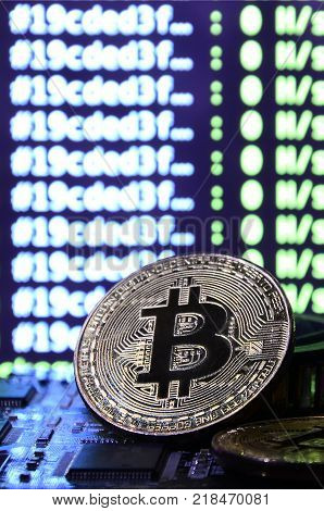 The digital process of cryptocurrency mining by using the GPUs. Bitcoins and video card on a working display and mining screen