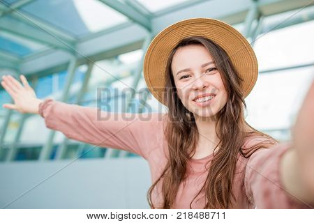 Young woman in international airport walking with her luggage.
