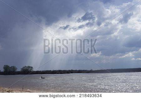 fisherman floating in the river in cloudy weather