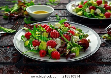 Fresh Tasty Raspberry salad with avocado, green vegetables, nuts, feta cheese, olive oil and herbs. healthy food