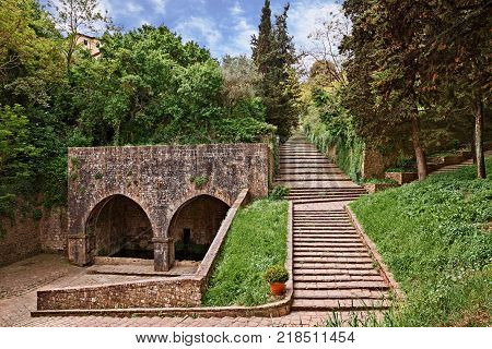 Volterrra, Pisa, Tuscany, Italy: the ancient Fonte di Docciola, a fount built in 1254 at the entrance of the old town and the staircase that leads to the historic city center