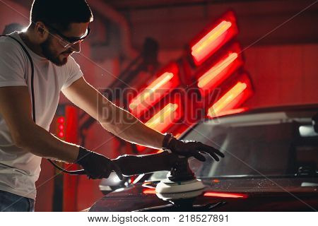 Car polish wax. worker hands holding a polisher and polish car