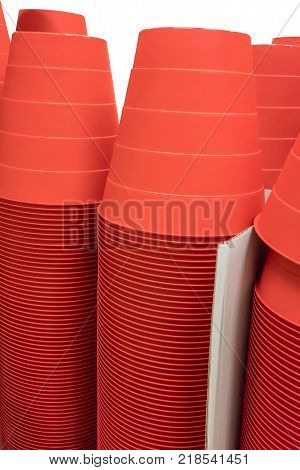 Stacks of red plastic buckets in white corrugated boxes isolated on white background with path selection