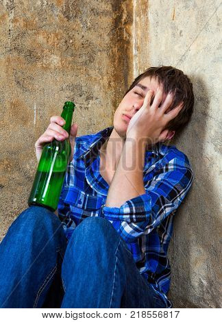Sad Young Man with a Beer by the Old Wall