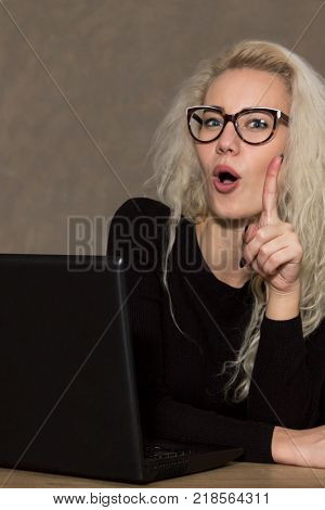 Portrait of a Young Woman in Glasses with a Computer