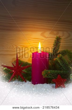 Avent candle and christmas decoration isolated on wood background. Christmas background with snow, candle and red stars.