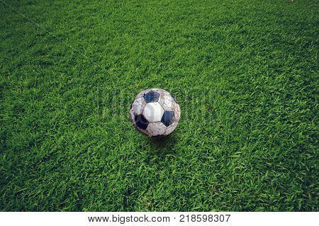 Old soccer ball left on the lawn. Lonely concept.
