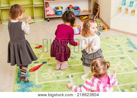Group of little children dancing and claping in hands