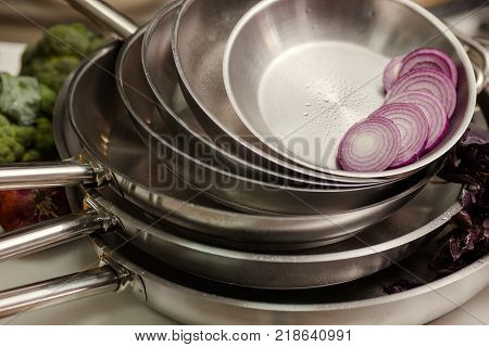 Stack of professional kitchen pans. Restaurant cooking untensils. Healthy food and proper nutrition concept