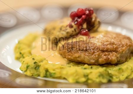 Meat patties or frikadeller in chese and mushroom sauce decorated with berries