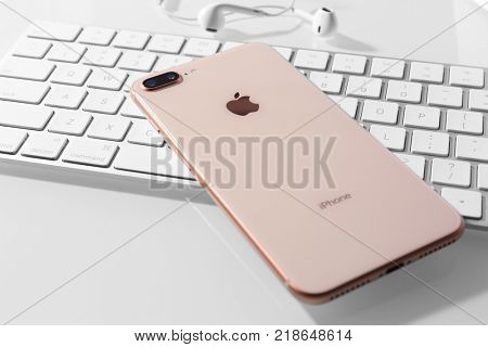 KIEV, UKRAINE - OCTOBER 23, 2017: iPhone 8 Plus Gold on computer keyboard, closeup