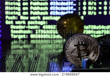 The digital process of cryptocurrency mining by using the GPUs. Bitcoins and video card on a working display and mining screen