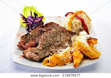 Grilled pork steak with rice and potatoes