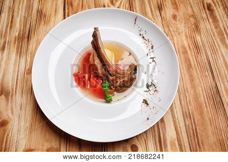 Plate with tasty chorba on wooden table