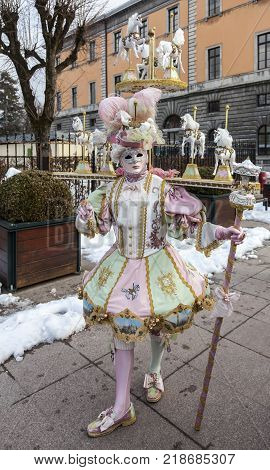 Annecy France February 23 2013: Image of a person in a complex disguise with horses posing in Annecy France during a Venetian Carnival which celebrates the beauty of the real Venice.